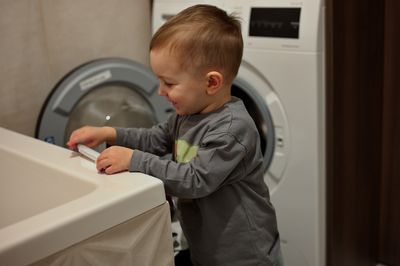 Portrait of cute little toddler playing in bathroom