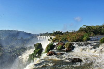 Scenic view of waterfall against sky