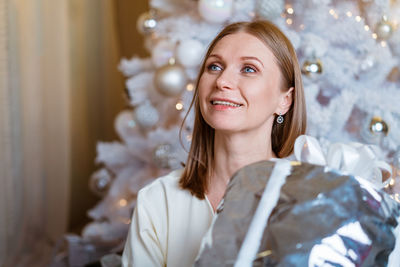 Christmas, new year. beautiful woman in light dress and socks sits on floor