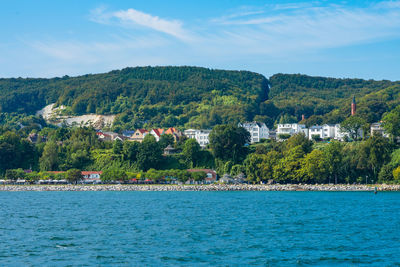 Scenic view of sea by buildings against sky