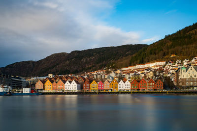 Scenic view of sea and buildings in town against sky