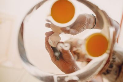 Woman breaking egg in bowl