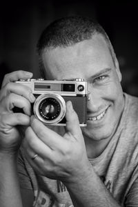 Portrait of smiling man photographing through camera