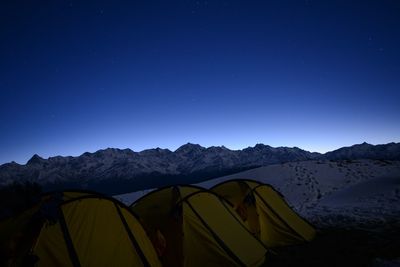 Scenic view of mountains against blue sky at night