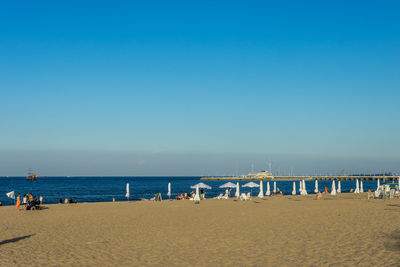 Scenic view of beach against clear blue sky