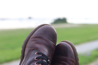 Low section of person wearing shoes on field