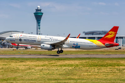 Airplane on airport runway against sky