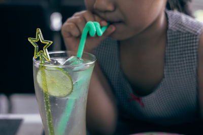 Close up and selective focus shot of lemonade soda in cocktail glass with fancy straw and lemon 