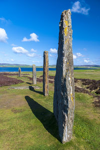 Wooden posts on field against sky