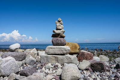 Stack of stones on beach against sky