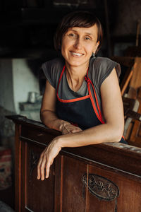 Professional female restorer or carpenter looking at camera, smiling