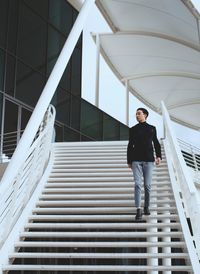 Full length of young man standing on staircase