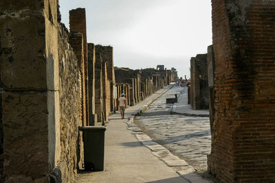 Road amidst old ruin built structure against sky