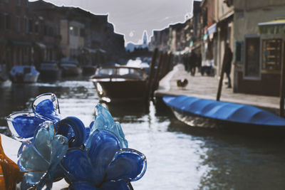 Close-up of boats in canal by buildings in city