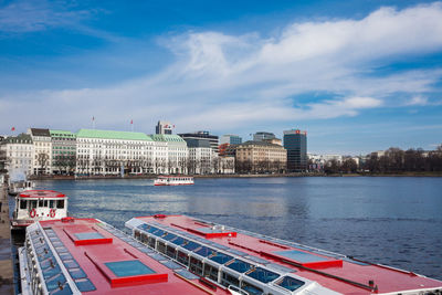 City at waterfront against cloudy sky