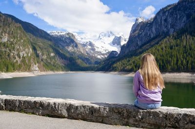 Rear view of gurl sitting by lake