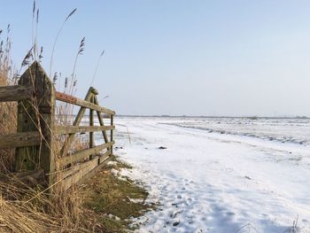 Scenic view of beach against clear sky during winter