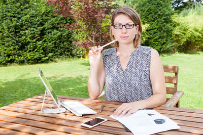 Portrait of young woman working at yard