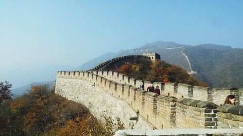 People on mountain against clear sky