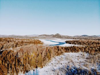 Scenic view of snow covered land against clear blue sky