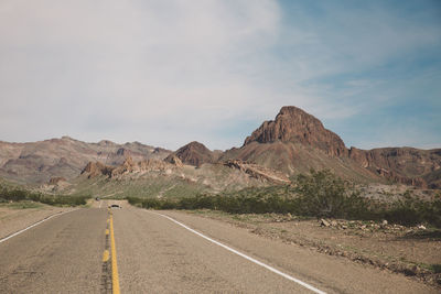 Empty road by mountain against sky