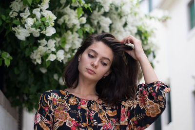 Young woman with hand in hair looking down