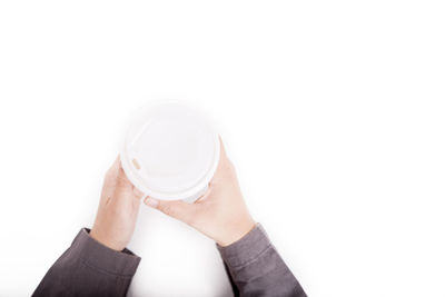 Close-up of woman holding glass over white background