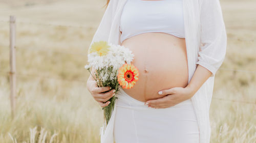 Midsection of woman holding flower