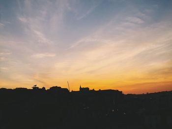 Silhouette city against sky during sunset