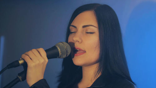 Close-up of woman singing during concert