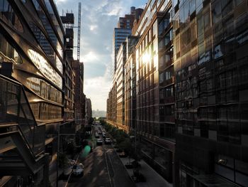 Cars on road amidst buildings in city against sky