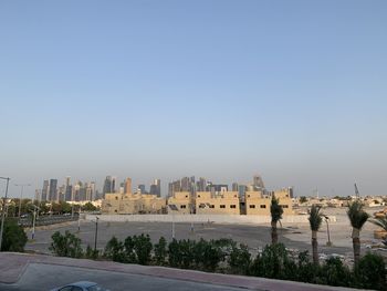 Buildings in city against clear blue sky