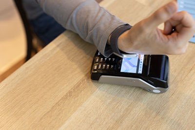 Midsection of man using smart phone on table