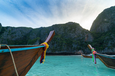Boat in sea against mountains