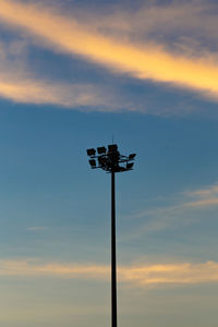 Low angle view of floodlight against sky during sunset