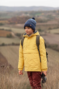 Rear view of boy on field during winter