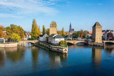 Bridge over river in city against sky