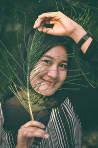 Portrait of young woman holding plant