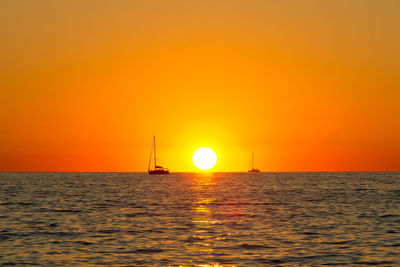 Boat sailing in sea at sunset