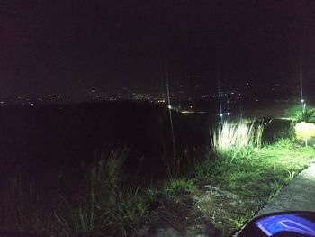 Scenic view of illuminated field against sky at night