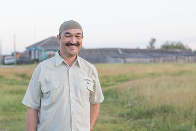 Portrait of smiling young man standing on field