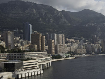 Modern buildings by sea against sky in city