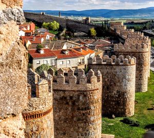Wall tower bastion avila spain made yellow stone bricks with view of town and countryside 