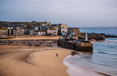 Scenic view of sea by town against sky