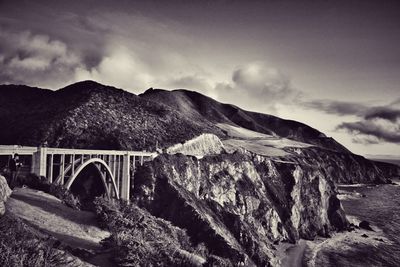 Arch bridge over mountains against sky