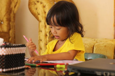 Close-up of cute girl learning at home