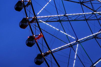 Low angle view of ferris wheel against clear blue sky