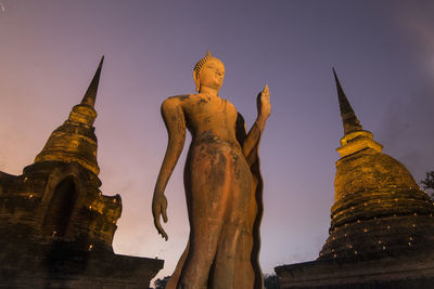 Low angle view of statues on building against sky