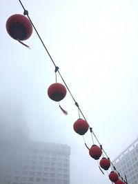 Low angle view of red lanterns hanging against sky