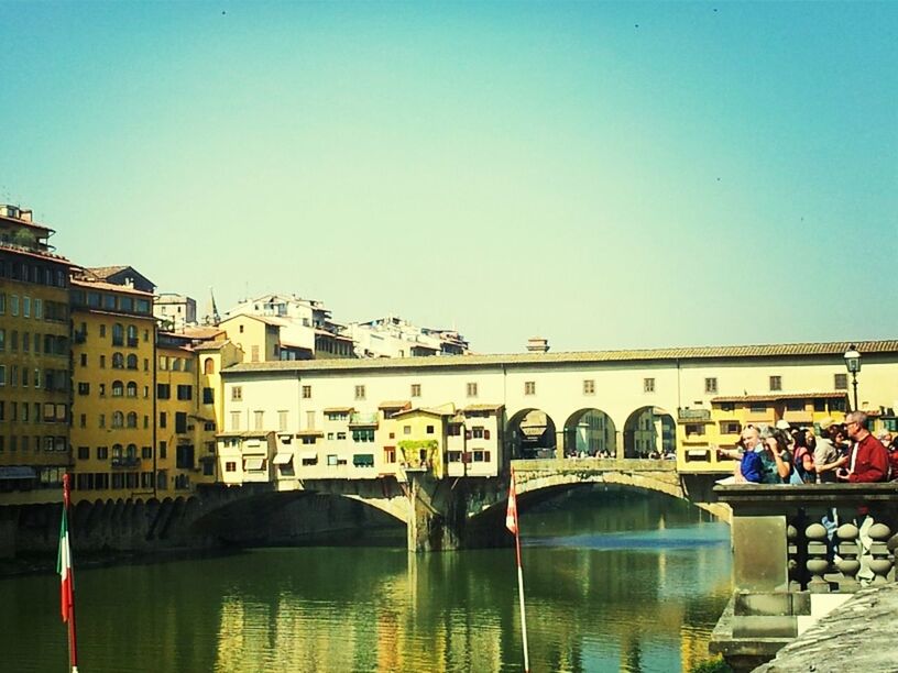 architecture, built structure, clear sky, water, building exterior, copy space, reflection, waterfront, arch, river, connection, bridge - man made structure, canal, bridge, arch bridge, city, incidental people, travel destinations, blue, outdoors